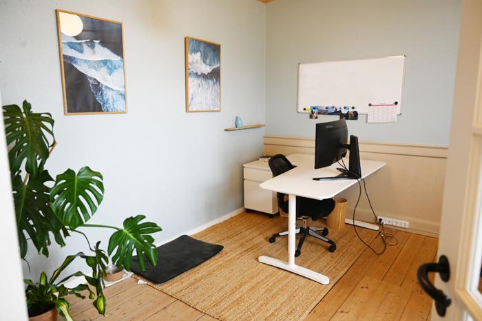 Lukket kontor med hæve-sænkebord, planter og whiteboard