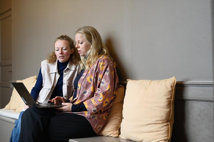 To fra huset arbejder sammen i sofaen under vinduet